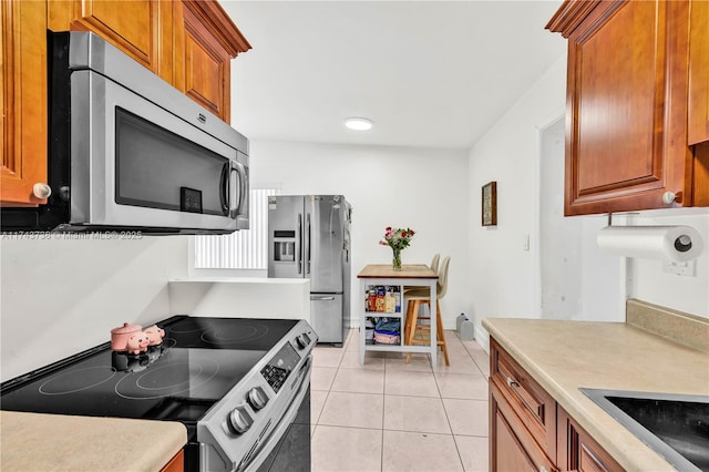 kitchen featuring appliances with stainless steel finishes and light tile patterned floors