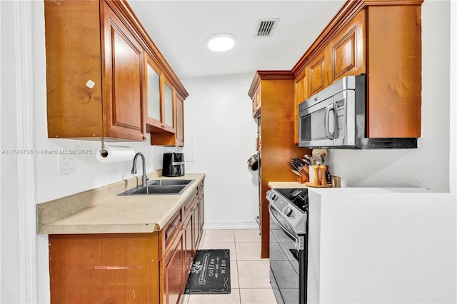 kitchen featuring sink, range with electric stovetop, and light tile patterned floors