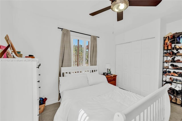 bedroom with light tile patterned flooring, ceiling fan, and a closet