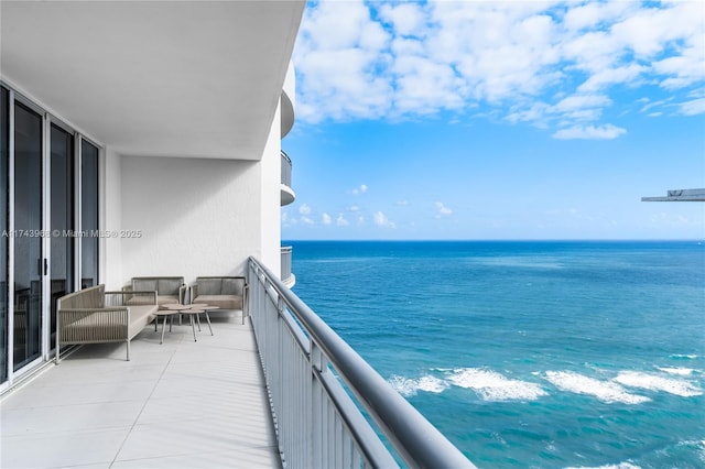 balcony featuring a water view and an outdoor living space