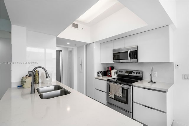 kitchen with white cabinetry, appliances with stainless steel finishes, and sink