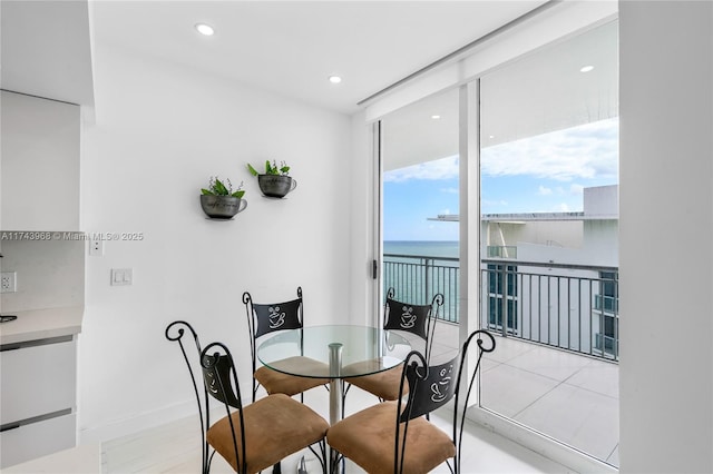 dining room with a water view and a wall of windows