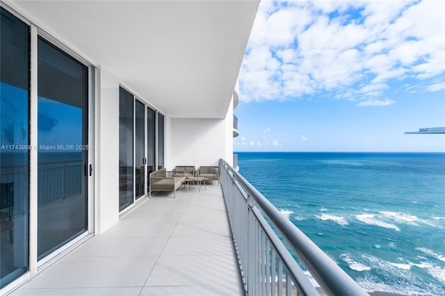 balcony with outdoor lounge area and a water view