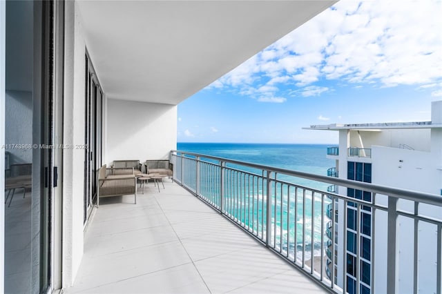 balcony with a water view and an outdoor hangout area