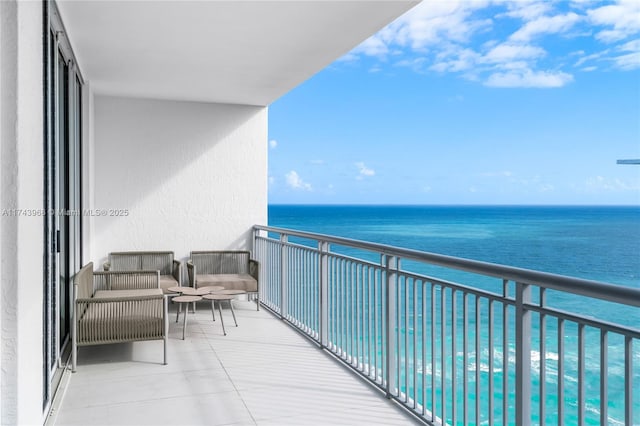 balcony featuring an outdoor living space and a water view