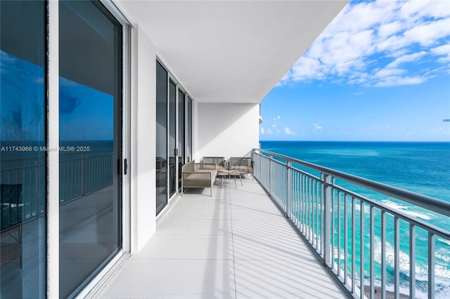 balcony with a water view and an outdoor hangout area