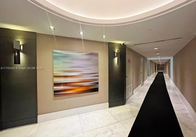 3300 NE 192nd St Unit 111, Aventura, FL 33180 - hallway with light marble finish floors and baseboards
