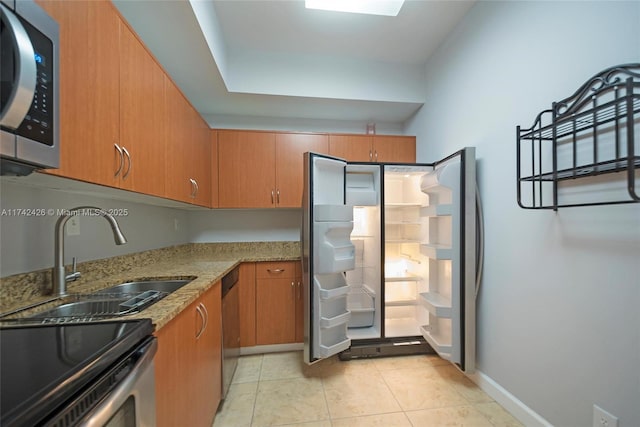 3300 NE 192nd St Unit 111, Aventura, FL 33180 - kitchen with appliances with stainless steel finishes, a sink, brown cabinets, light stone counters, and light tile patterned flooring
