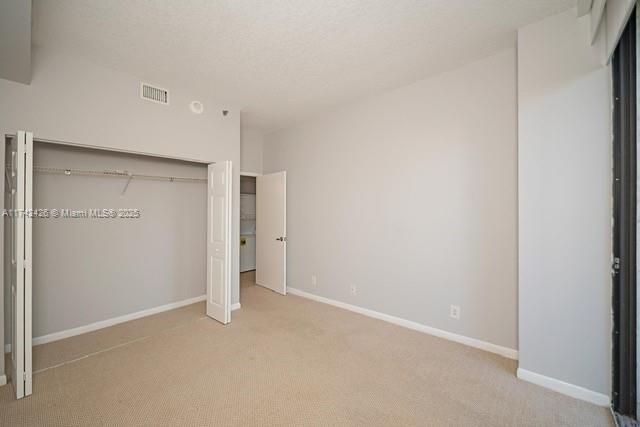 3300 NE 192nd St Unit 111, Aventura, FL 33180 - unfurnished bedroom featuring carpet, a closet, and baseboards