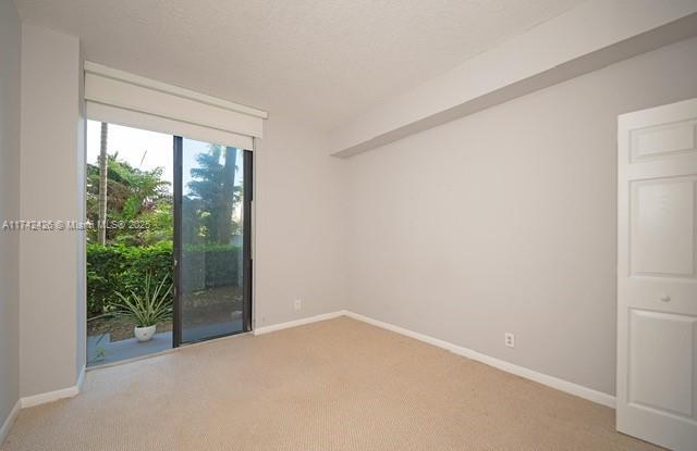 3300 NE 192nd St Unit 111, Aventura, FL 33180 - empty room with light carpet and baseboards
