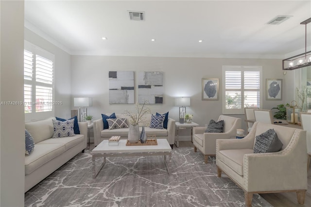 living room featuring crown molding, plenty of natural light, and a chandelier