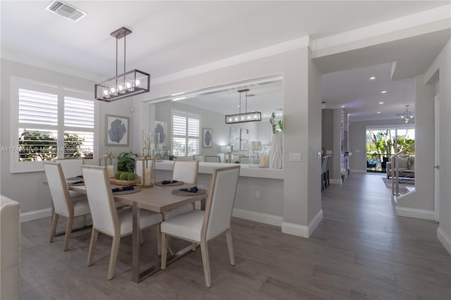 dining area featuring ornamental molding, dark hardwood / wood-style floors, and a notable chandelier