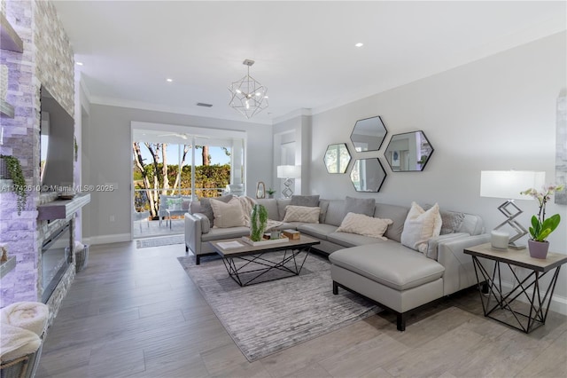 living room with crown molding, an inviting chandelier, and light hardwood / wood-style flooring