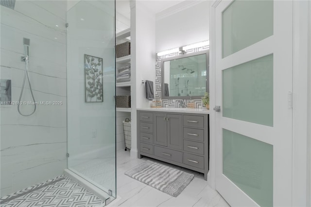 bathroom featuring a tile shower, vanity, and crown molding