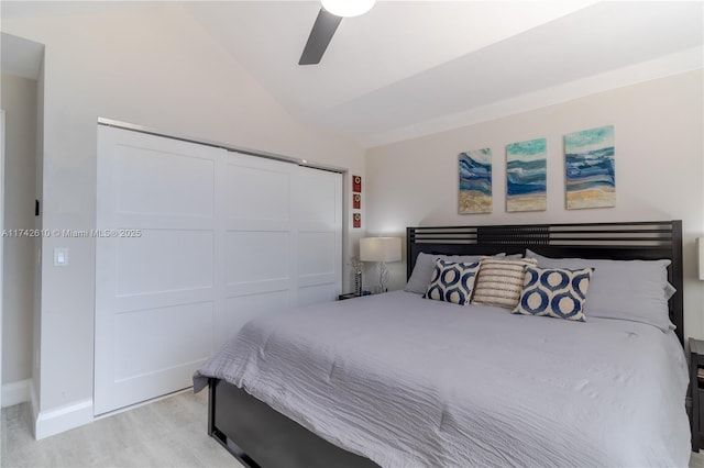 bedroom with vaulted ceiling, ceiling fan, light hardwood / wood-style floors, and a closet