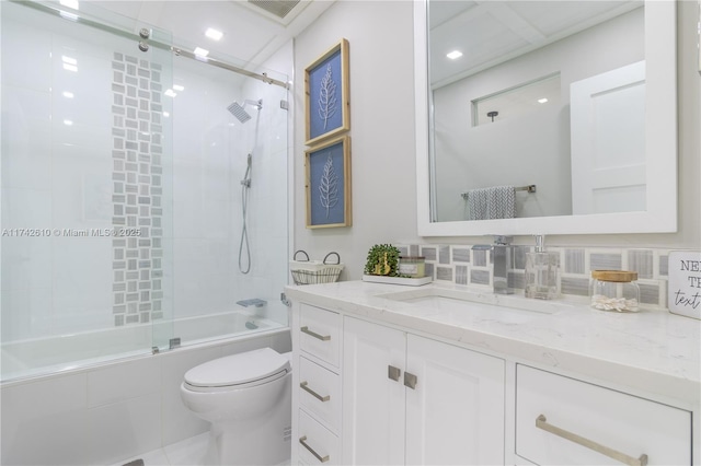 full bathroom with enclosed tub / shower combo, vanity, toilet, and backsplash