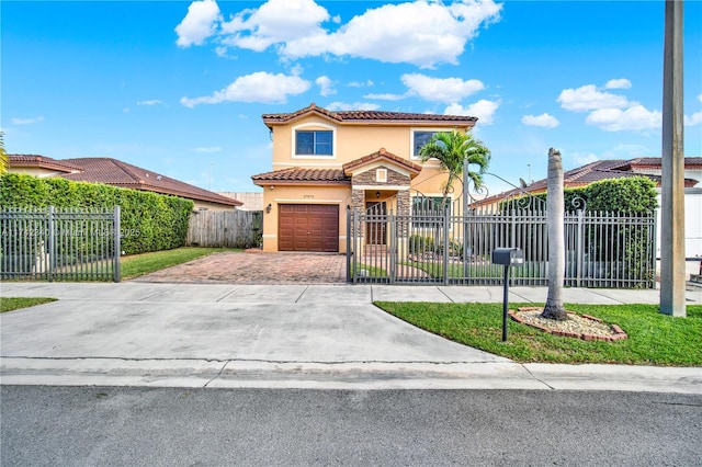 mediterranean / spanish-style home with a fenced front yard, a garage, a tiled roof, decorative driveway, and stucco siding