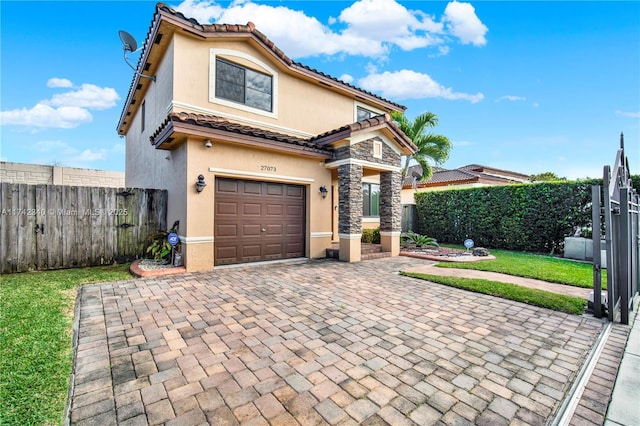 view of front of home with a garage, fence, a tiled roof, decorative driveway, and stucco siding