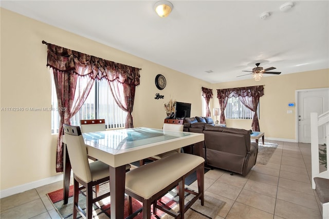 tiled dining space with a wealth of natural light and ceiling fan