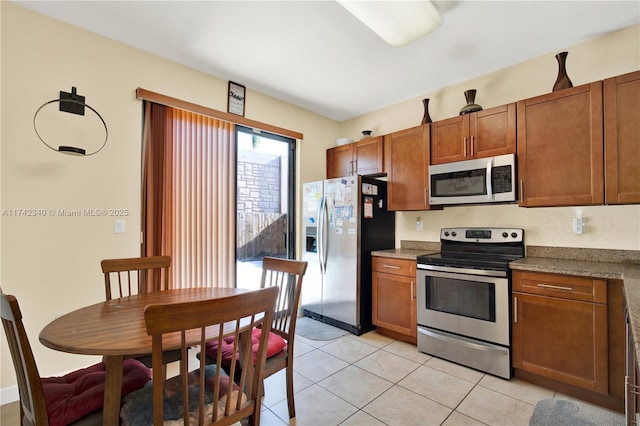 kitchen with light tile patterned floors and stainless steel appliances