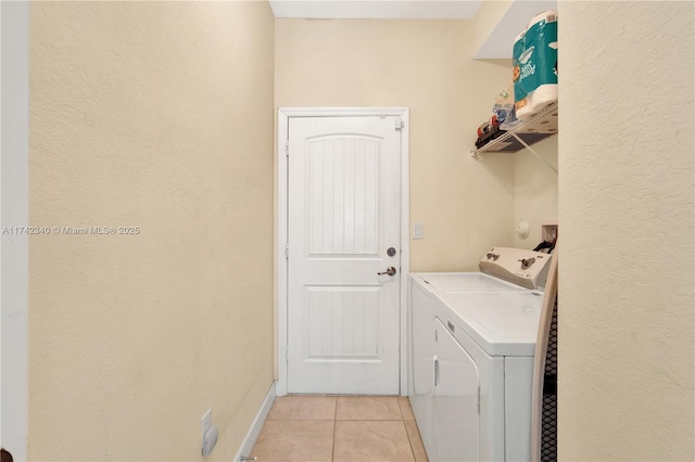 washroom with washing machine and clothes dryer and light tile patterned floors