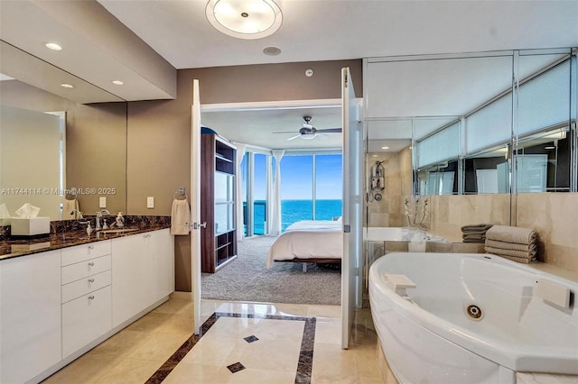 bathroom with vanity, shower with separate bathtub, ceiling fan, and a water view