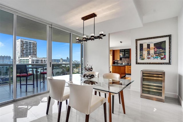 tiled dining space with wine cooler, a notable chandelier, and floor to ceiling windows