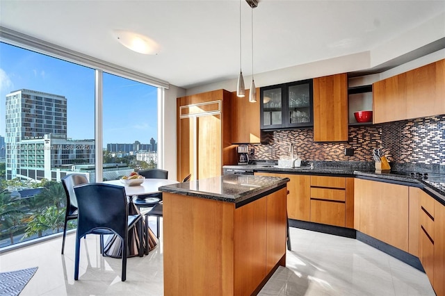 kitchen featuring hanging light fixtures, a kitchen island, backsplash, and a wall of windows