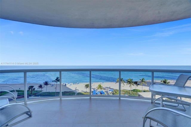 balcony with a water view and a view of the beach