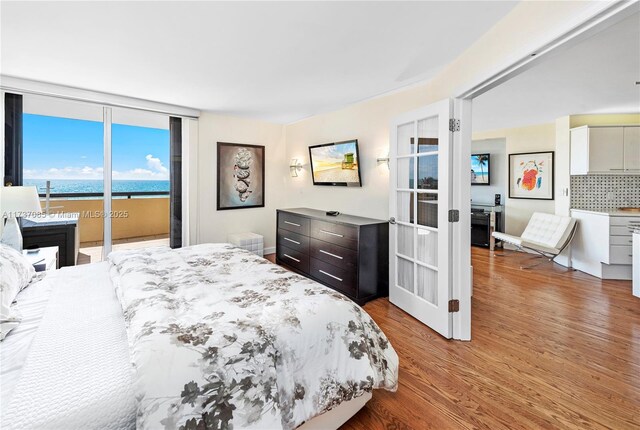 2555 Collins Ave Unit 607, Miami Beach, FL 33140 - bedroom featuring wood finished floors, access to exterior, a water view, and french doors
