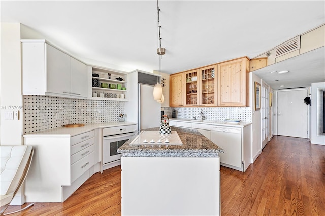 2555 Collins Ave Unit 607, Miami Beach, FL 33140 - kitchen with white appliances, open shelves, backsplash, light wood-style floors, and a kitchen island