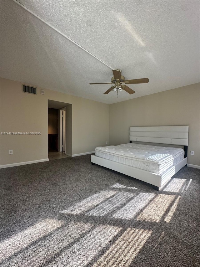 1750 NE 191st St Unit 225-4, Miami, FL 33179 - unfurnished bedroom featuring ceiling fan, dark carpet, and a textured ceiling