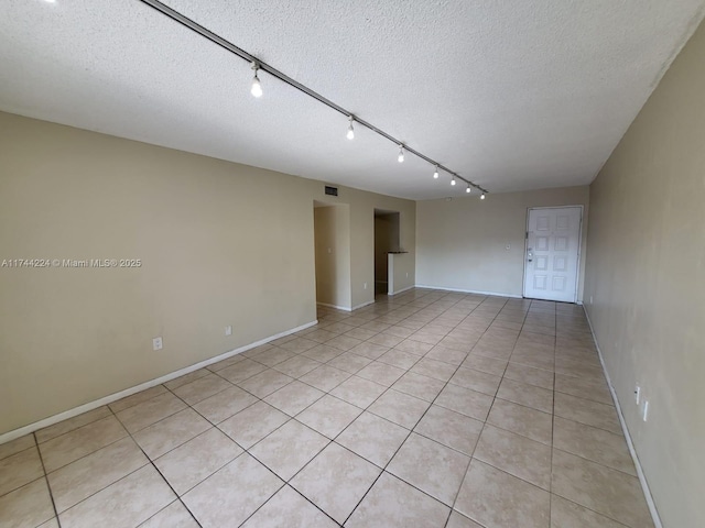 unfurnished room featuring light tile patterned floors and a textured ceiling