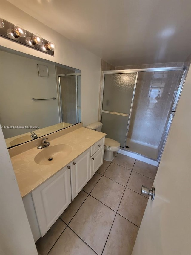 bathroom with tile patterned flooring, vanity, toilet, and an enclosed shower