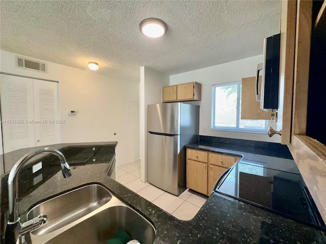 kitchen featuring light tile patterned flooring, appliances with stainless steel finishes, sink, and a textured ceiling