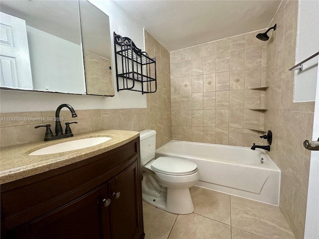 full bathroom featuring tile walls, vanity, tiled shower / bath, tile patterned floors, and toilet