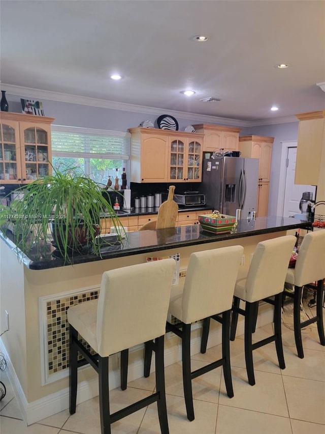 kitchen with stainless steel refrigerator with ice dispenser, radiator, crown molding, and kitchen peninsula