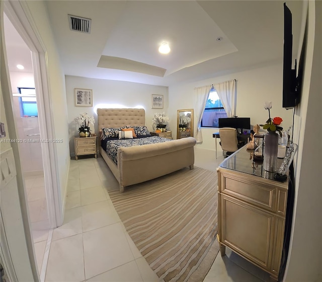 bedroom with a raised ceiling, light tile patterned floors, and visible vents