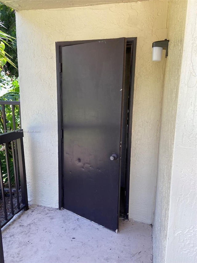 view of exterior entry featuring a balcony