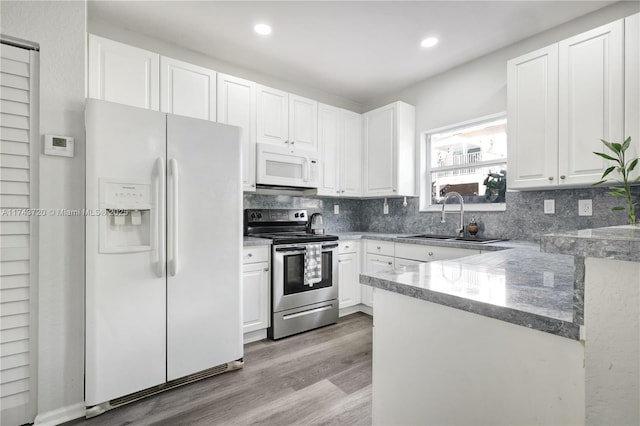 7459 NW 17th Dr, Pembroke Pines, FL 33024 - kitchen with white appliances, white cabinets, decorative backsplash, wood finished floors, and stone countertops