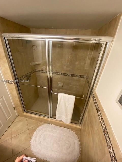 bathroom with tile patterned flooring and a shower with shower door