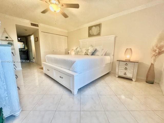 tiled bedroom with ornamental molding, ceiling fan, and a closet