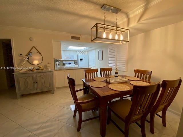 tiled dining area featuring ornamental molding and a textured ceiling