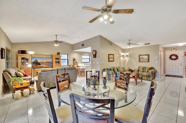 dining area featuring lofted ceiling, ceiling fan, a textured ceiling, and light tile patterned flooring