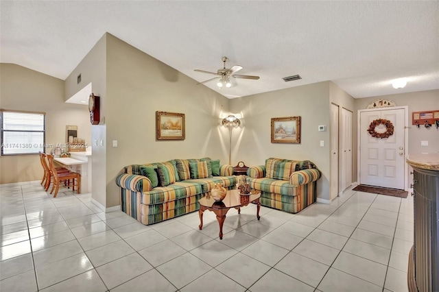 tiled living room featuring ceiling fan and vaulted ceiling