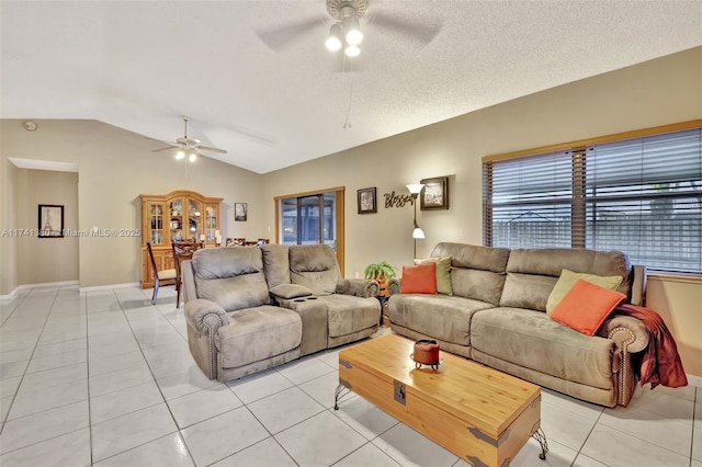 living room featuring light tile patterned floors, a textured ceiling, vaulted ceiling, and ceiling fan