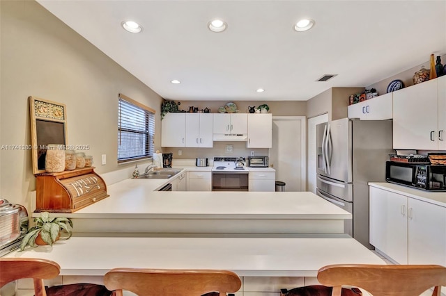 kitchen featuring white cabinetry, kitchen peninsula, and white range with electric stovetop