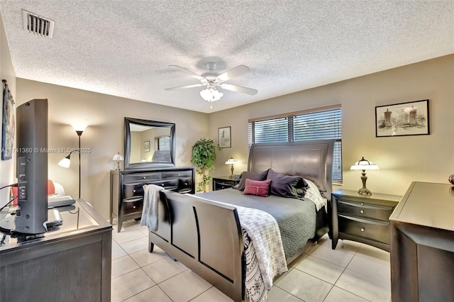 bedroom featuring light tile patterned flooring, ceiling fan, and a textured ceiling