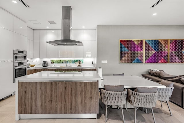 285 W Mashta Dr, Key Biscayne, FL 33149 - kitchen with island exhaust hood, modern cabinets, a sink, white cabinets, and a center island
