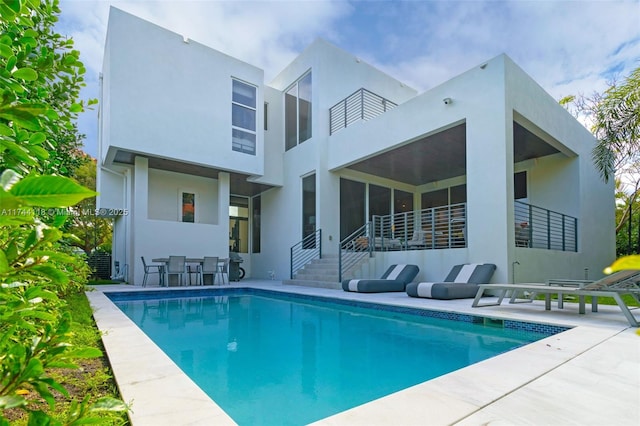 285 W Mashta Dr, Key Biscayne, FL 33149 - back of house with an outdoor pool, stucco siding, and a patio
